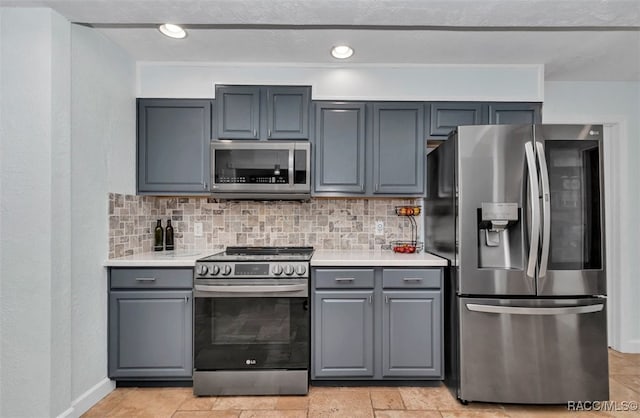 391 E Falconry Ct, Hernando, FL 34442 - kitchen featuring stainless steel appliances, gray cabinetry, backsplash, and light countertops