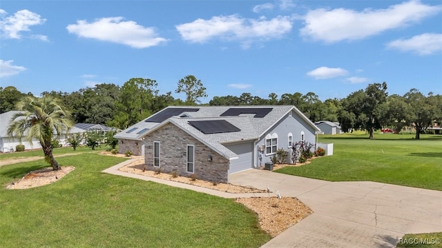391 E Falconry Ct, Hernando, FL 34442 - view of front of property with a front yard, roof mounted solar panels, concrete driveway, and a shingled roof