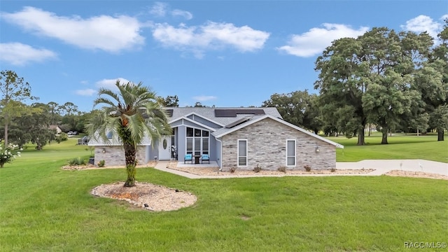 391 E Falconry Ct, Hernando, FL 34442 - rear view of house with roof mounted solar panels, a lawn, a sunroom, and stone siding
