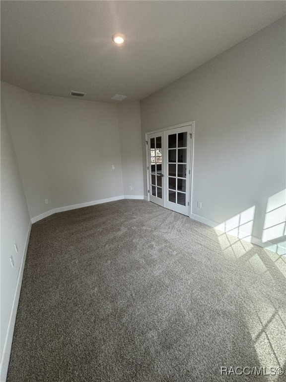 spare room featuring carpet floors and french doors