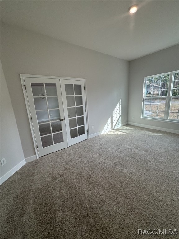 carpeted empty room featuring french doors