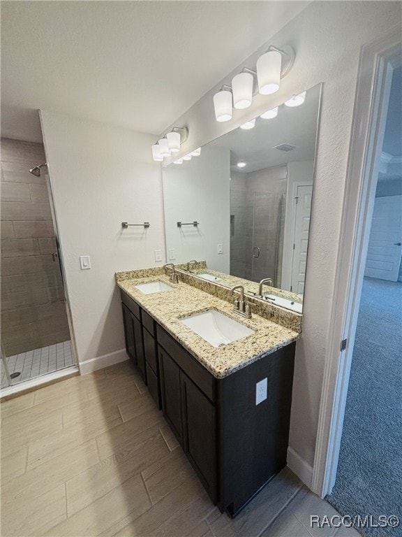 bathroom with hardwood / wood-style flooring, vanity, and walk in shower