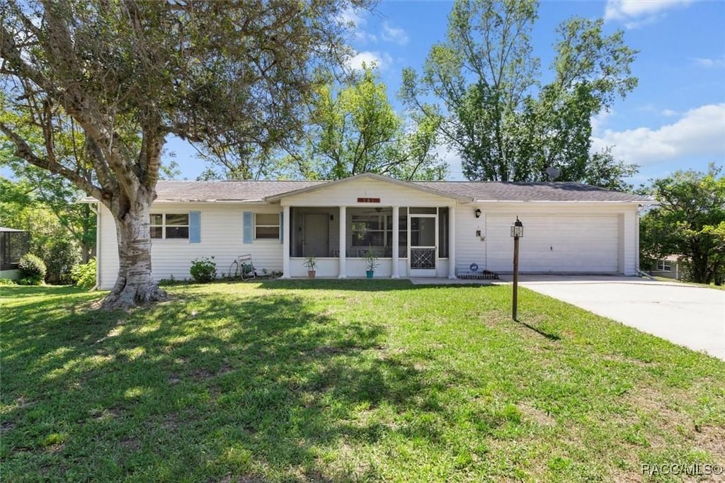 101 S Lucille St, Beverly Hills, FL 34465 - ranch-style home with a front lawn, driveway, a sunroom, and a garage