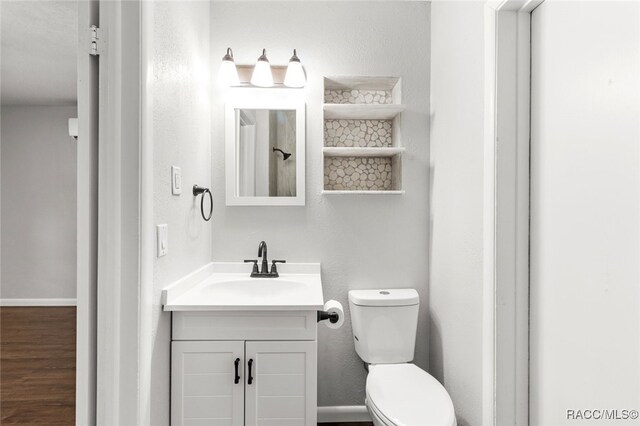 bathroom with vanity, hardwood / wood-style flooring, and toilet