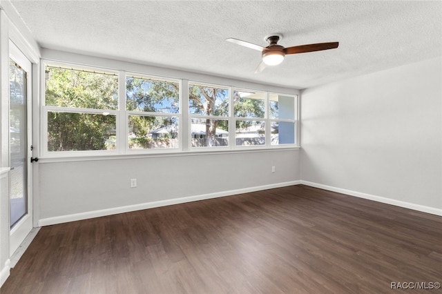 spare room featuring dark hardwood / wood-style floors, plenty of natural light, and a textured ceiling