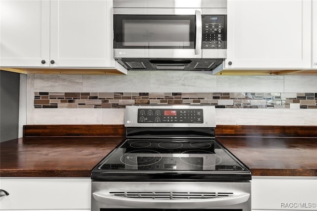 kitchen with backsplash, white cabinets, and stainless steel appliances