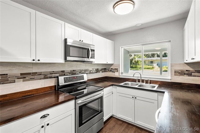 kitchen featuring sink, white cabinets, dark hardwood / wood-style floors, and appliances with stainless steel finishes