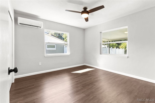 empty room featuring a wall unit AC, ceiling fan, and dark wood-type flooring