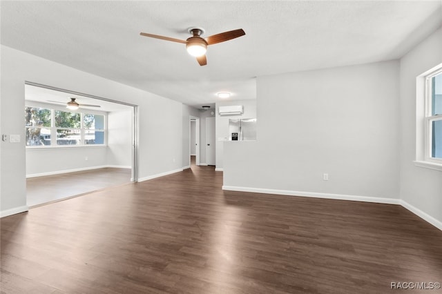 unfurnished room with ceiling fan, dark hardwood / wood-style flooring, and a wall mounted air conditioner