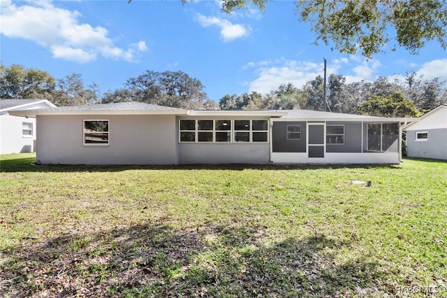 back of property featuring a sunroom and a yard