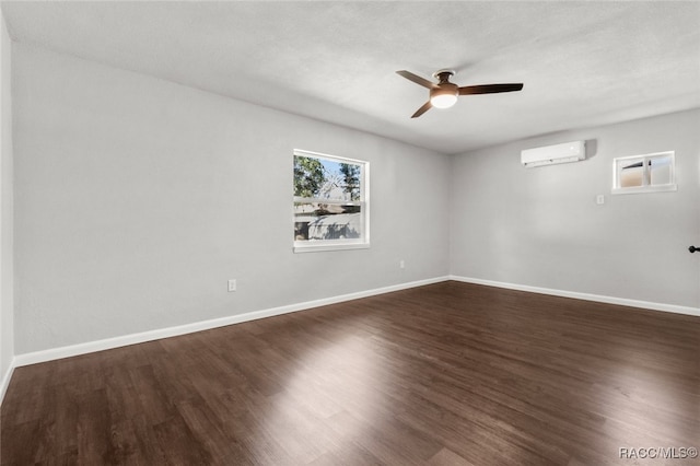 empty room featuring a textured ceiling, a wall mounted AC, dark wood-type flooring, and ceiling fan