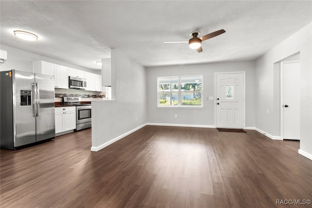 kitchen with white cabinetry, ceiling fan, dark hardwood / wood-style floors, a textured ceiling, and appliances with stainless steel finishes