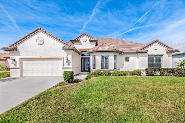 mediterranean / spanish-style home featuring a front lawn and a garage