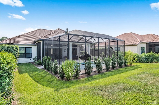 back of house featuring a yard and a lanai