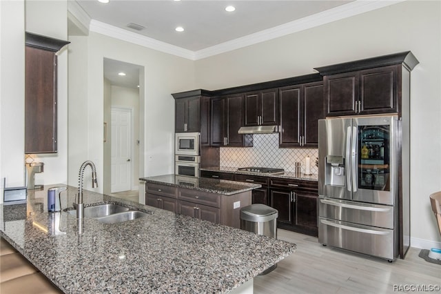 kitchen featuring dark stone countertops, sink, kitchen peninsula, and stainless steel appliances