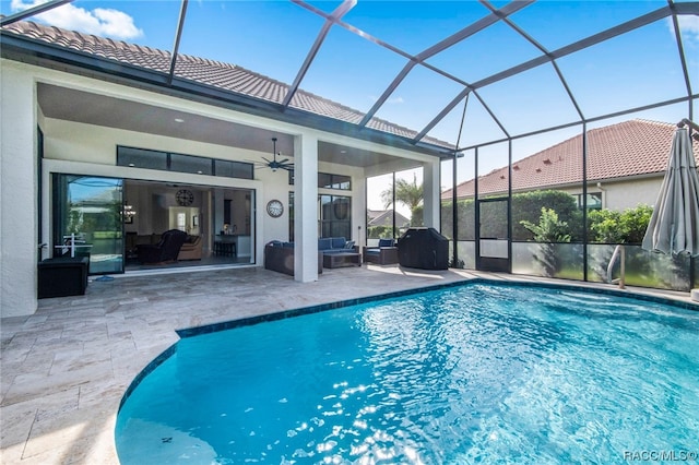 view of swimming pool featuring ceiling fan, an outdoor hangout area, a patio, and glass enclosure