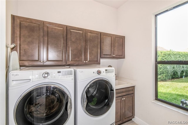 washroom featuring washer and dryer and cabinets