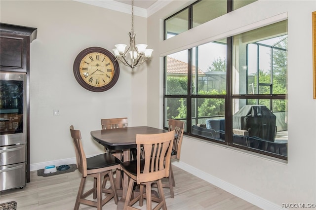 dining space featuring light hardwood / wood-style flooring, a notable chandelier, and ornamental molding