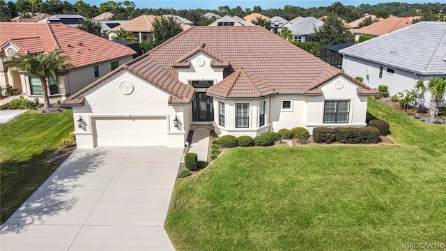 mediterranean / spanish house with a front yard and a garage