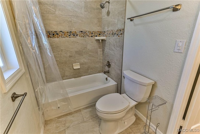 full bath featuring toilet, a textured wall, and shower / bath combo