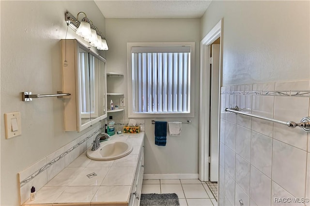 bathroom with a textured ceiling, vanity, and tile patterned flooring