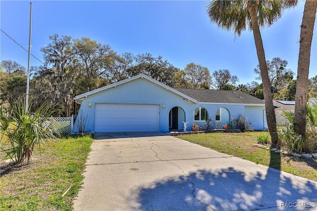 single story home featuring fence, driveway, an attached garage, stucco siding, and a front lawn