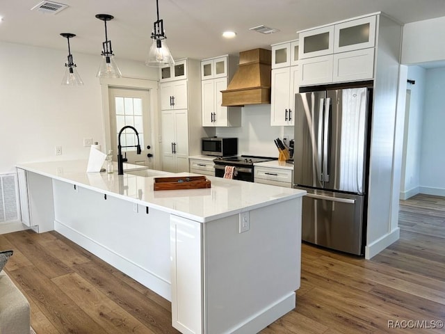 kitchen with premium range hood, dark wood-type flooring, white cabinetry, decorative light fixtures, and appliances with stainless steel finishes