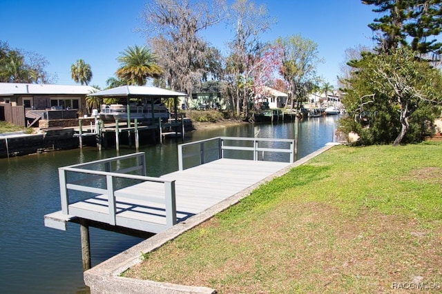 dock area with a lawn and a water view