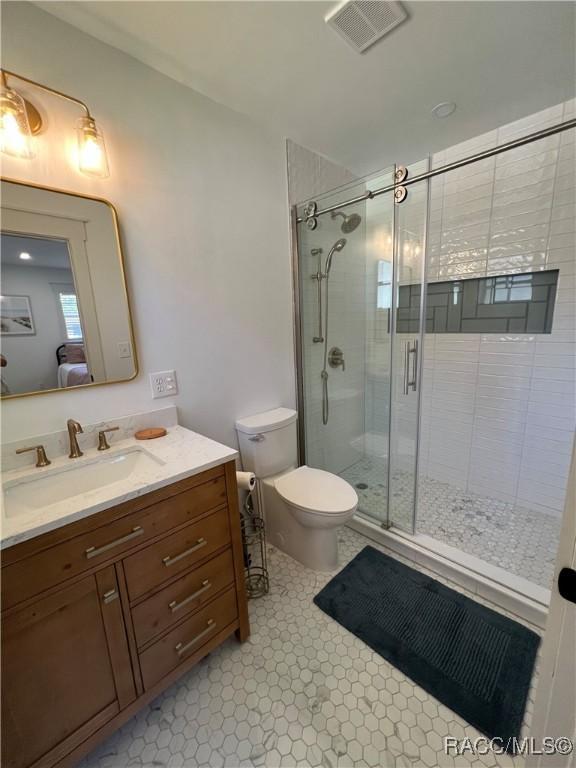 bathroom with vanity, toilet, and an enclosed shower