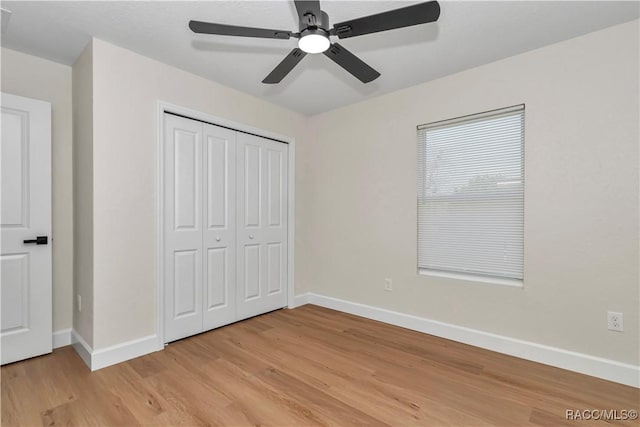 unfurnished bedroom with light hardwood / wood-style floors, ceiling fan, and a closet