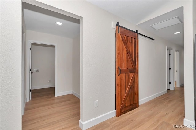 hallway featuring light hardwood / wood-style flooring and a barn door