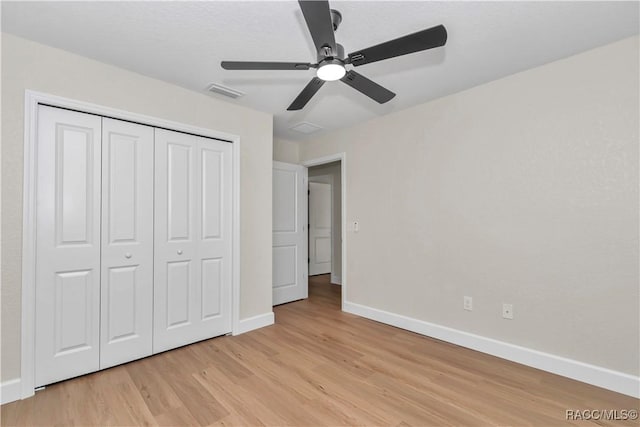 unfurnished bedroom with light hardwood / wood-style floors, ceiling fan, and a closet