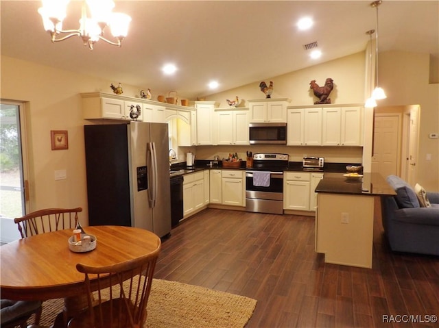 kitchen with lofted ceiling, hanging light fixtures, stainless steel appliances, and white cabinets