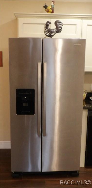 room details with stainless steel refrigerator with ice dispenser, white cabinetry, dark hardwood / wood-style flooring, and black dishwasher