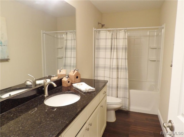 full bathroom featuring hardwood / wood-style flooring, vanity, shower / tub combo, and toilet