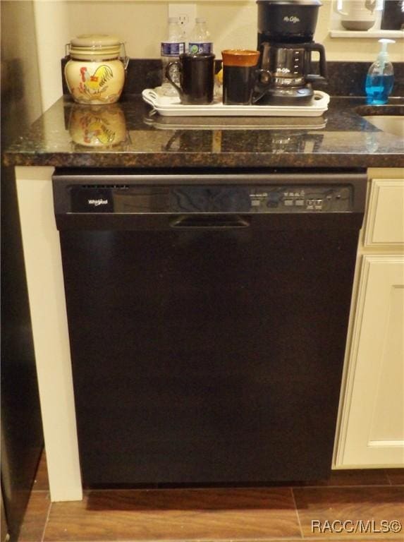 interior space featuring dark stone countertops, white cabinets, wood-type flooring, and black dishwasher