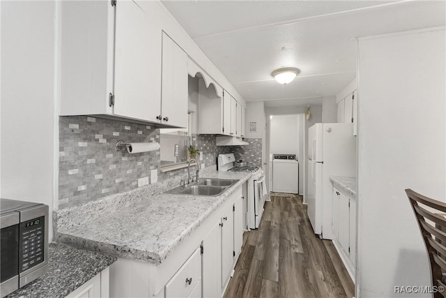 kitchen with white appliances, dark wood-type flooring, a sink, white cabinetry, and backsplash