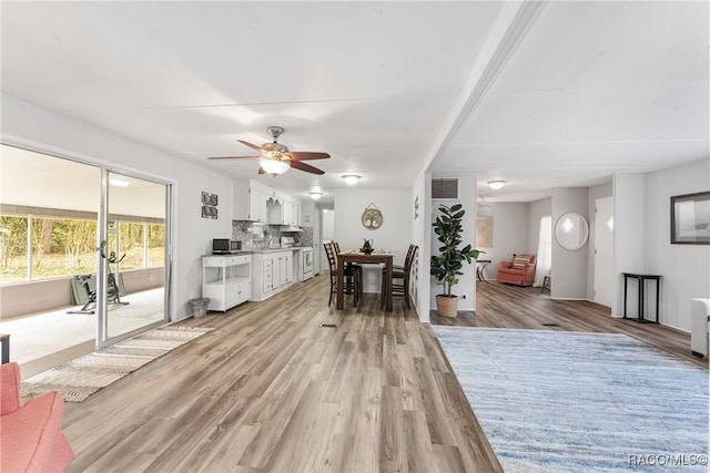 interior space featuring light wood-style floors, visible vents, and a ceiling fan