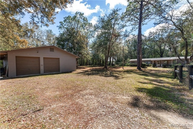 view of yard with an outbuilding, driveway, and a garage