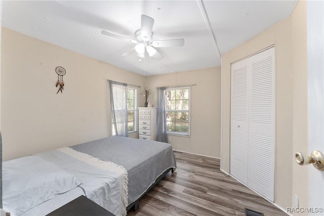 bedroom featuring ceiling fan, a closet, and wood finished floors