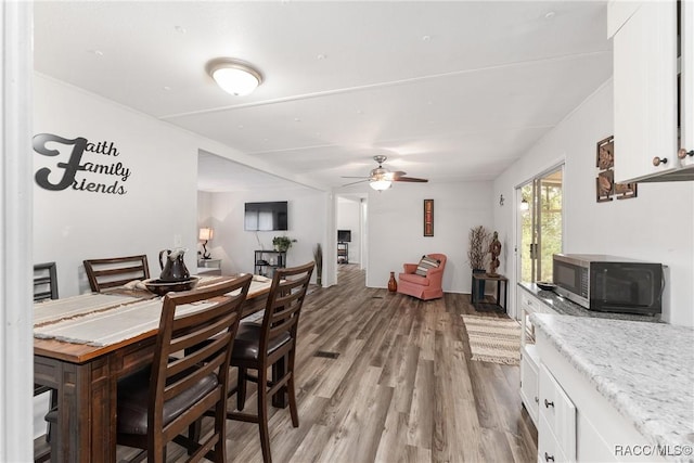 dining space with light wood-type flooring and a ceiling fan