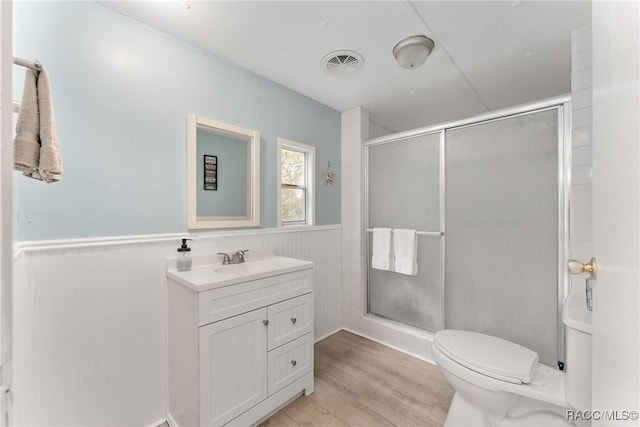 full bath with wainscoting, visible vents, a shower stall, and toilet