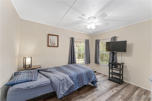 bedroom with crown molding, ceiling fan, and wood finished floors