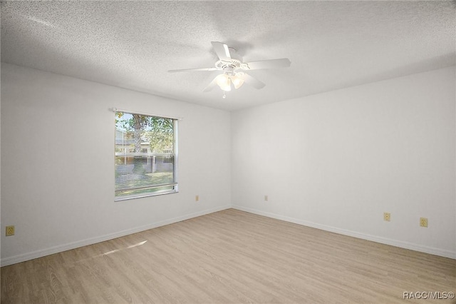 empty room with ceiling fan, light hardwood / wood-style floors, and a textured ceiling