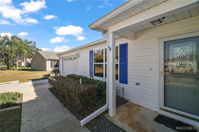 doorway to property with a yard and a garage