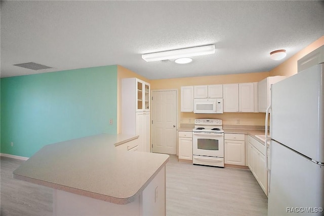 kitchen with kitchen peninsula, a textured ceiling, white appliances, and light hardwood / wood-style flooring