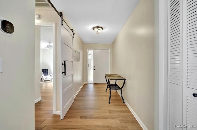 hall featuring a barn door and light wood-type flooring