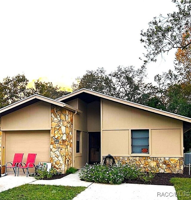 view of front of house featuring a garage and central AC