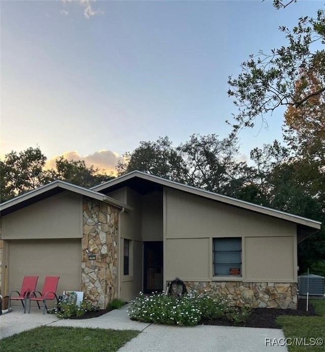 view of front of property with a garage and cooling unit