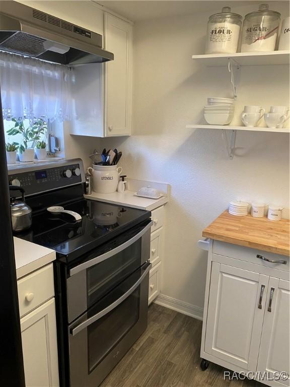 kitchen featuring range with two ovens, under cabinet range hood, white cabinetry, dark wood-style floors, and open shelves